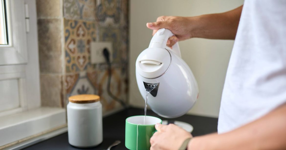 2_Person-Pouring-Hot-Water-from-Electric-Kettle-into-Mug.jpg
